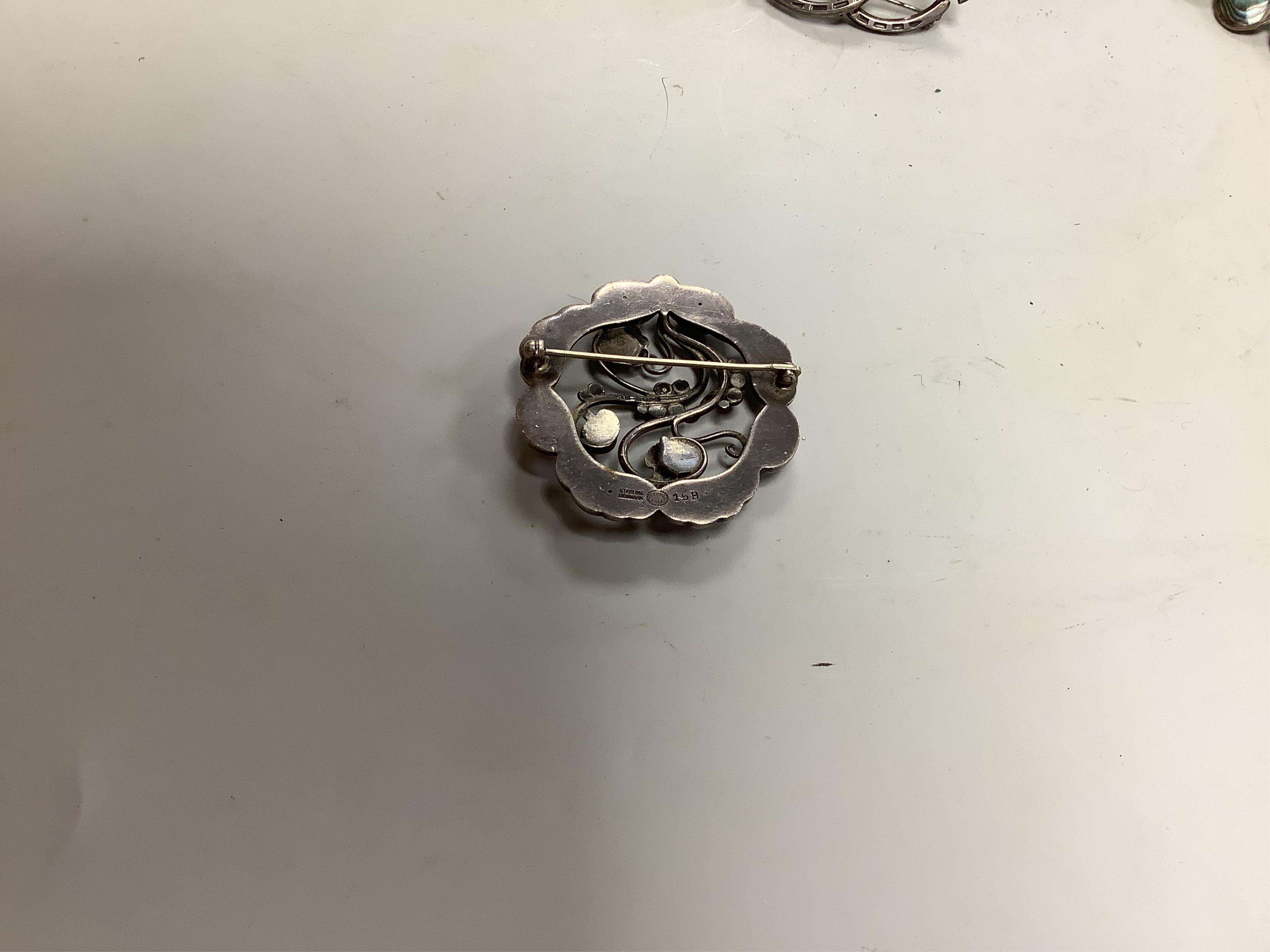 A group of silver brooches including one by Georg Jensen, comprising: a foliate brooch by Georg Jensen, 4.8cm diameter, signed Georg Jensen, numbered 158, British hallmarks, date letter d for 1959; three Scottish hardsto